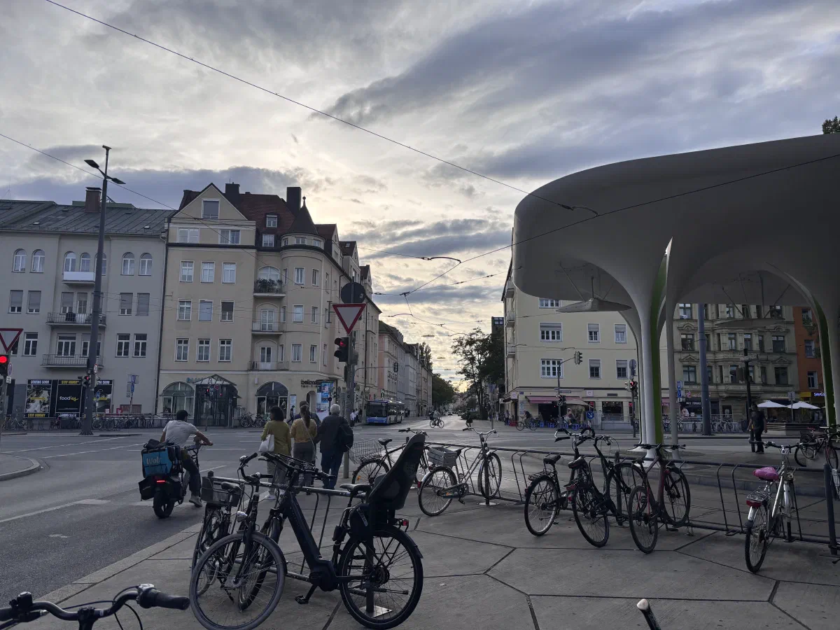 A street intersection in Munich, with pedestrians, cars and parked bikes